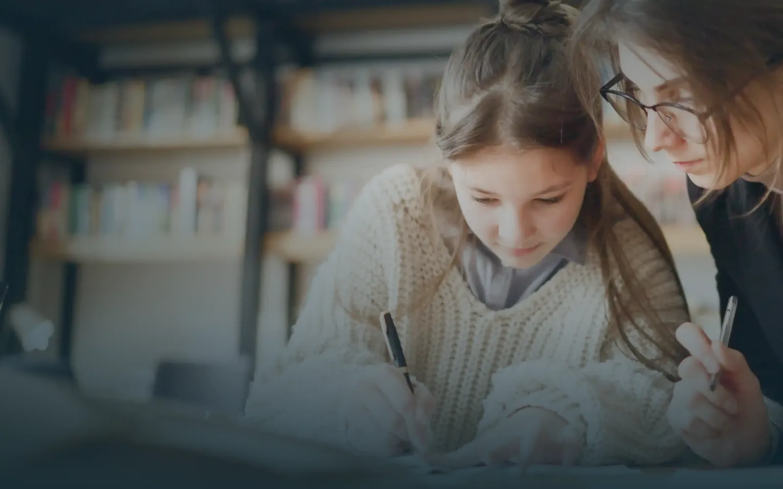 Dos jóvenes estudiando juntas, conectadas con sus familias en tiempo real a través de ellu