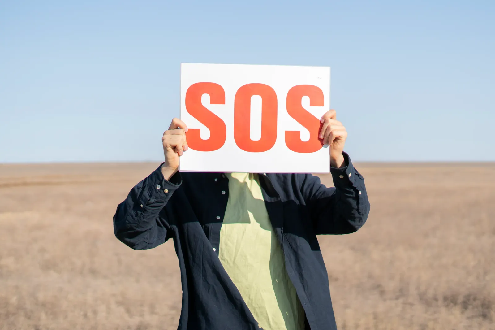 Persona con cartel de SOS pidiendo ayuda