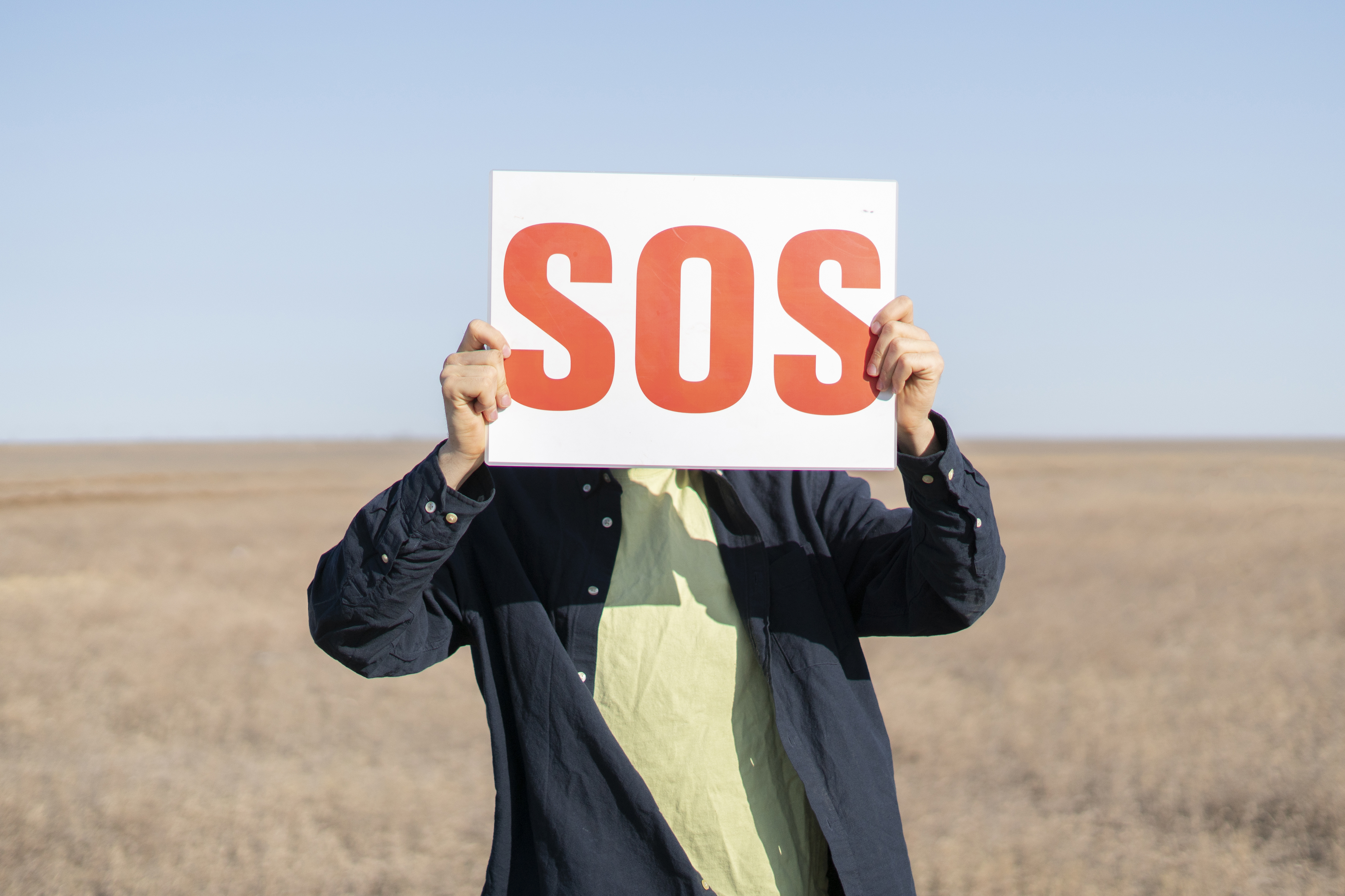 Persona con cartel de SOS pidiendo ayuda